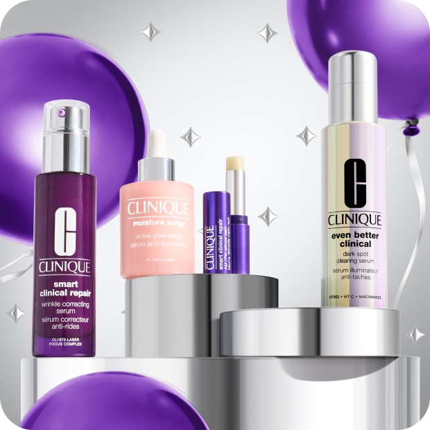 Selection of best-selling Clinique serums on a grey plinth, surrounded by purple balloons